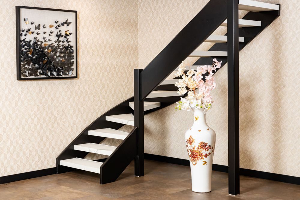Moderne open trap met zwarte trapwangen en witte treden in een stijlvolle showroom