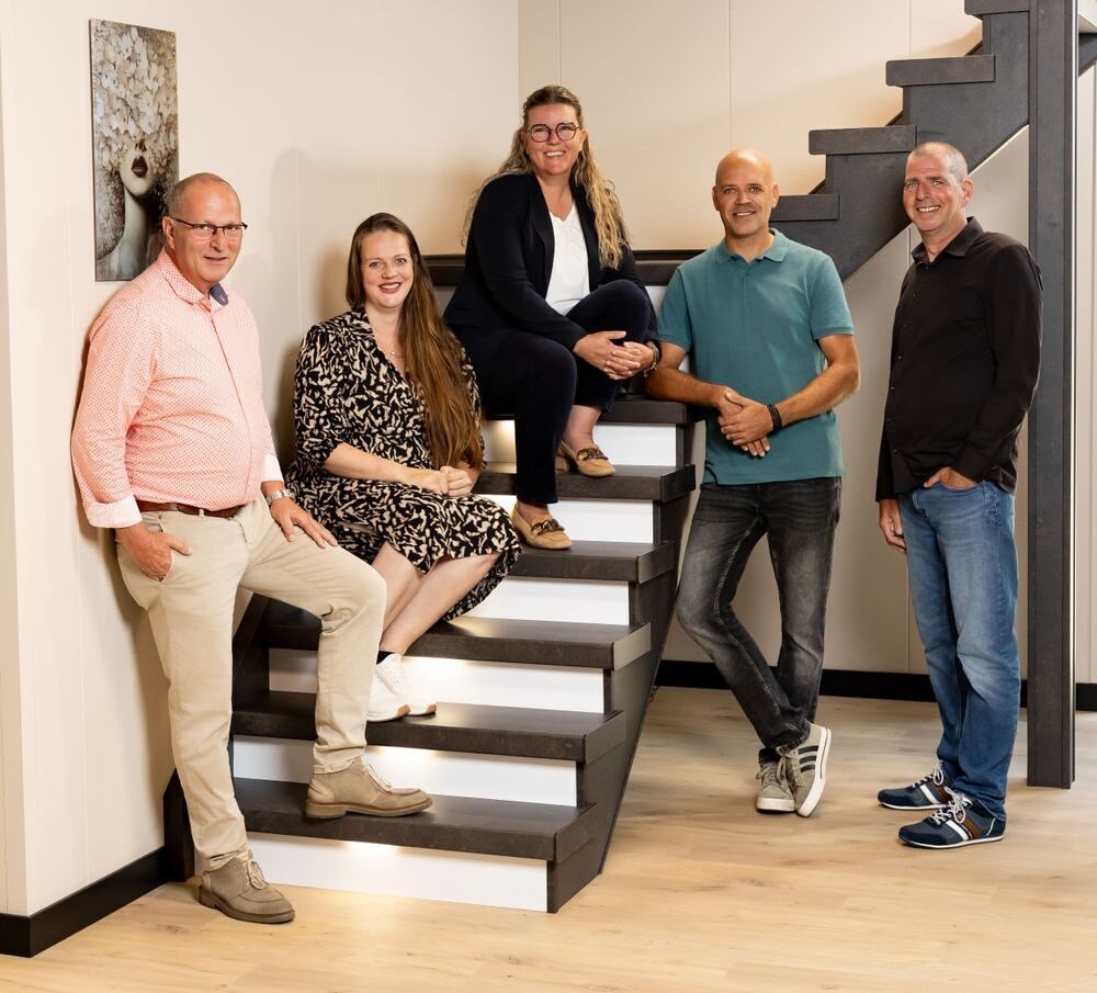 Het team van Traprenovatie Nederland samen op een gerenoveerde trap in de showroom